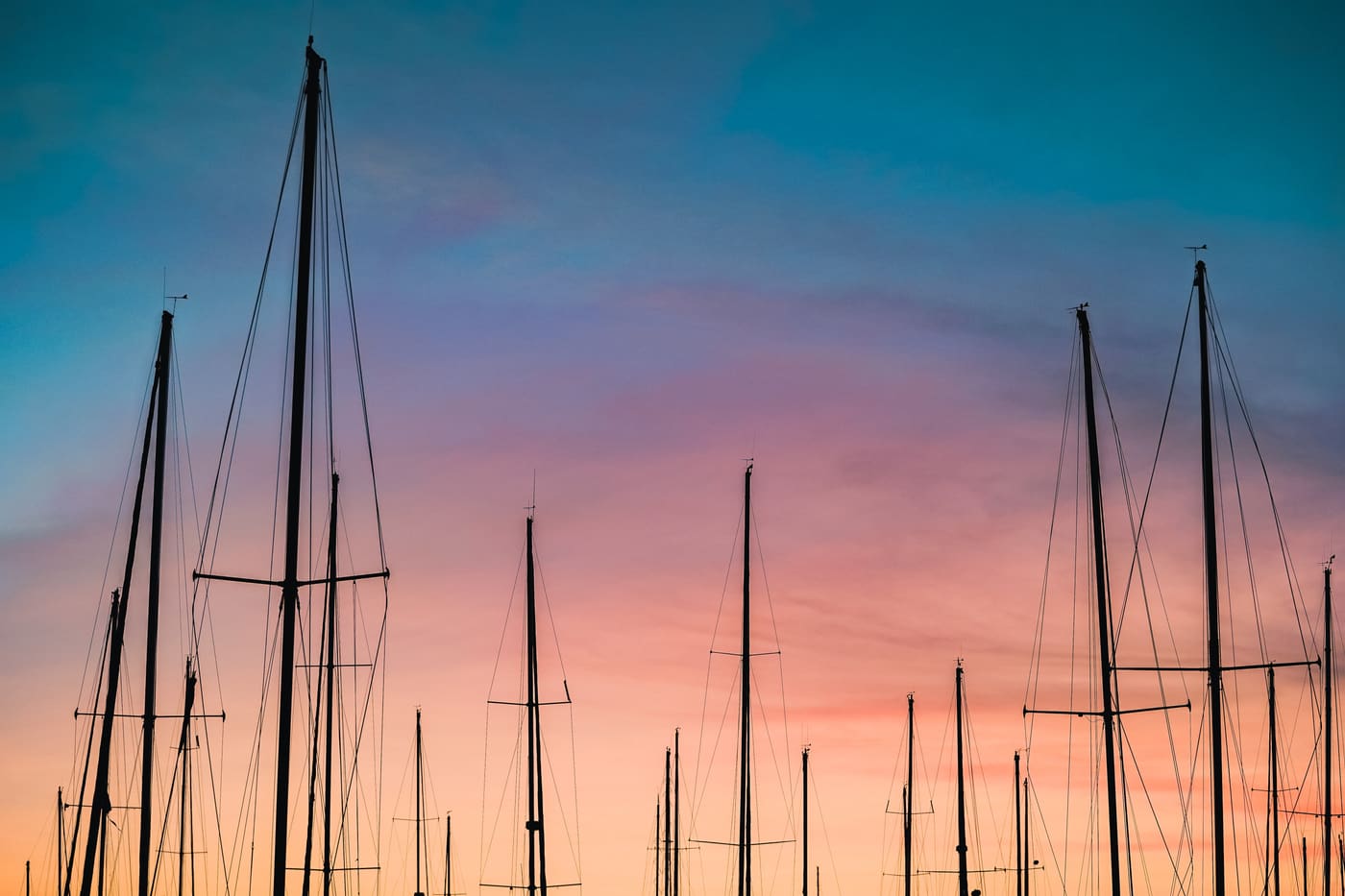 Master med VHF-antenner i en lystbådehavn ved solnedgang
